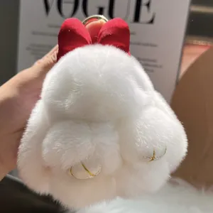 Detailed macro view of soft white plush bunny pendant with red ears and golden metal ring