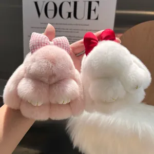 Detail of cute rabbit keychains with real rabbit fur bows in pink and white colors
