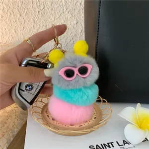 Dettaglio del portachiavi a bruco in peluche colorato con occhiali rosa sulla borsa