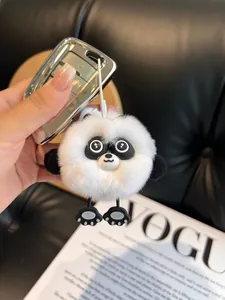 Detail of a fluffy white panda plush keychain on a car key with high-quality faux rabbit fur