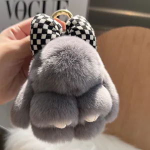 Close-up of grey plush rabbit keychain with checkered bow and golden metal hook
