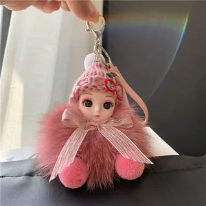 Detail van roze pluche pop sleutelhanger met gebreide muts en zijden lint decoratie