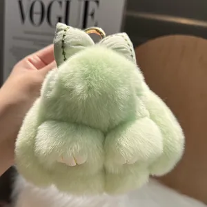Close-up of mint green rabbit plush keychain with a soft bow and golden metal ring