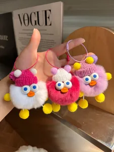 Detail von Enten-Plüschanhängern mit Strickmützen und Stahlringen in Weiß, Rosa, Lila