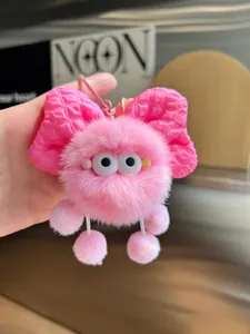 Detailed view of pink plush charm with checkered bow and soft faux fur texture