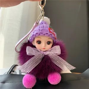 Detailopname van een paarse pluche pop sleutelhanger met grote ogen en een zachte bontbal
