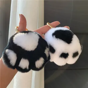 Detailed view of plush cat paw keychains in black and white with golden metal rings