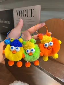 Detailansicht der flauschigen Enten-Plüschanhänger mit Strickmützen und Metallglocken