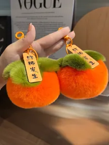 Dettaglio del portachiavi in peluche a forma di caco arancione con targhetta