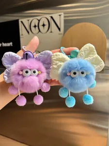 Detail of plush puff keychain featuring large textured bow and colorful metal bell