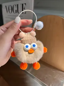 Details eines süßen braunen Plüsch-Enten-Schlüsselanhängers mit Mütze und Glocke