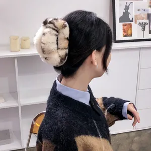 Oversized leopard print faux fur claw clip for voluminous hair styling in beige and brown