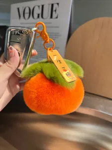 Dettaglio di un portachiavi a forma di cachi in peluche con pelliccia e etichetta creativa