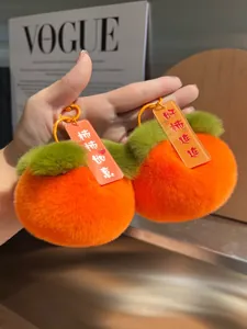 Dettaglio di ciondoli in peluche a forma di cachi con pelliccia sintetica arancione