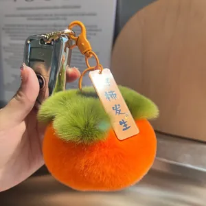 Portachiavi in peluche di cachi in pelliccia arancione con foglie verdi e clip in metallo