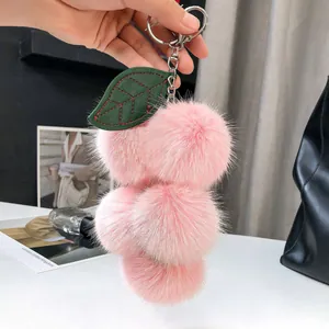 Dettaglio del portachiavi a uva in pelliccia di volpe rosa con foglia in pelle verde