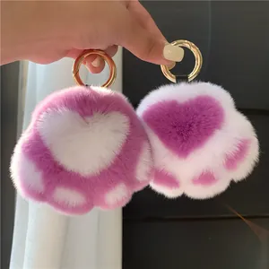 Detailed view of plush cat paw keychains with heart-shaped pads and golden metal rings