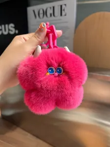 Dettaglio ciondolo a fiore di peluche rosso rosa con occhi blu e catena rosa