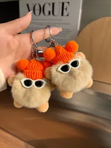 Détail de porte-clés en peluche avec bonnet orange tricoté et lunettes blanches