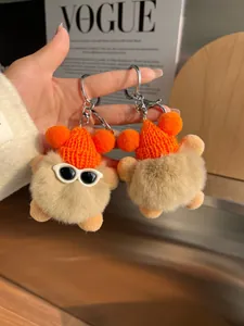 Détail du porte-clés en peluche kaki avec bonnet orange et lunettes de soleil