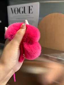 Dettaglio ravvicinato della trama del portachiavi in peluche rosa con morbide fibre