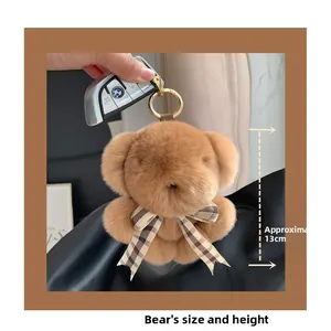 Detail of 13cm brown faux fur bear charm with plaid bow and gold metal keychain