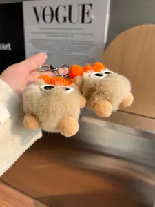 Détail d'un porte-clés en peluche douce avec bonnet orange et lunettes de soleil