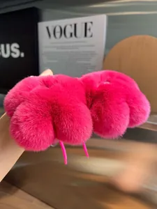 Dettaglio di pantofola in peluche rosa vivace con impronte di zampe realistiche