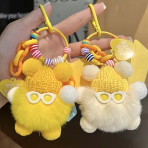 Close-up of colorful plush keychains with knit hats, sunglasses and heart tags