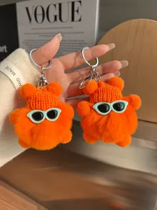 Gros plan de charms ours en peluche orange avec bonnets tricotés et lunettes