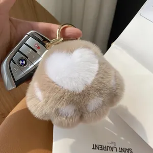 Cute cat paw plush keychain in light brown faux fur with golden ring and heart detail