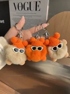 Détail de porte-clés en peluche avec mini bonnets tricotés, lunettes et fourrure douce