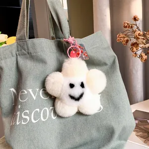 Portachiavi carino fiore di peluche con faccina sorridente su borsa di tela verde