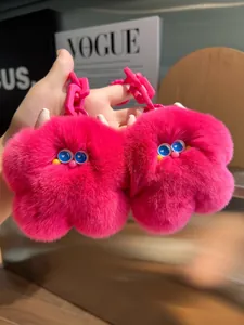 Dettaglio di portachiavi mostro in peluche rosa con occhi blu e catena in plastica