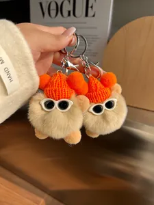 Gros plan de porte-clés en peluche mignons avec bonnets orange et lunettes de soleil