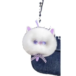 White faux fur cat plush keychain with purple bow in a blue denim pocket detail