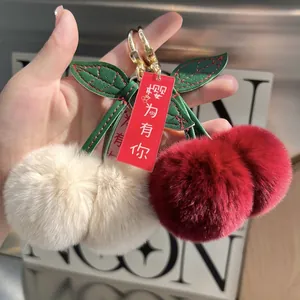 Faux rabbit fur cherry keychain with red and white plush balls and green leather leaves