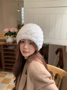 Close-up of white plush beanie with thick knitted texture and warm rabbit fur finish