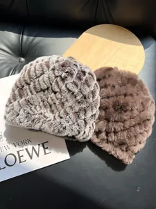 Close-up of thick real rabbit fur hats in brown and patterned grey for winter warmth