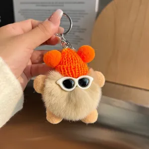 Porte-clés boule en fourrure beige avec bonnet orange et lunettes de soleil
