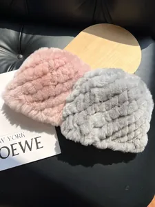 Detailed texture of woven rabbit fur winter hats in pink and grey plush knit
