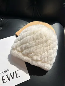 Detailed close-up of white plush hat with diamond quilt texture and faux rabbit fur