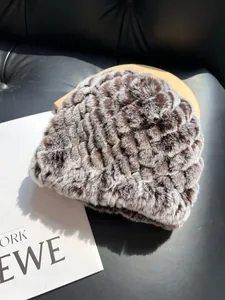 Detailed view of bicolor faux fur hat with brown and white wavy plush texture on a sofa