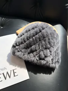 Detailed texture of grey rabbit fur knitted hat with thick stripes on a leather background