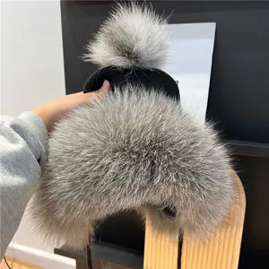 Dettaglio del bordo in pelliccia di volpe su un cappello invernale in maglia nera caldo