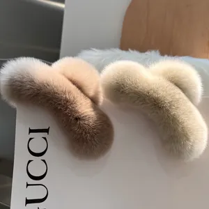 Detail of warm coffee and cream white faux rabbit fur hair claws with a plush texture