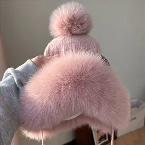 Cappello invernale rosa in maglia con bordo in ecopelliccia e grande pompon