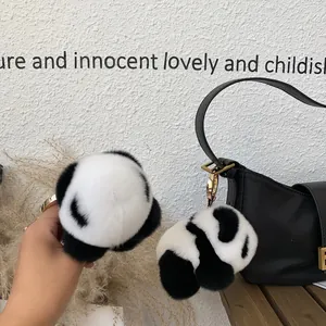 Dettaglio macro di un portachiavi panda di peluche con anello in metallo dorato