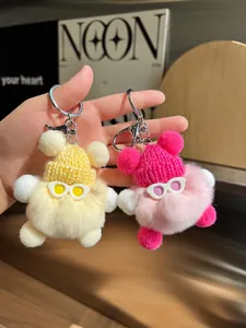 Vue détaillée de porte-clés ours en peluche avec bonnets en tricot et lunettes