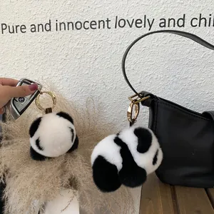 Dettaglio del portachiavi in peluche panda bianco e nero con chiusura in metallo dorato